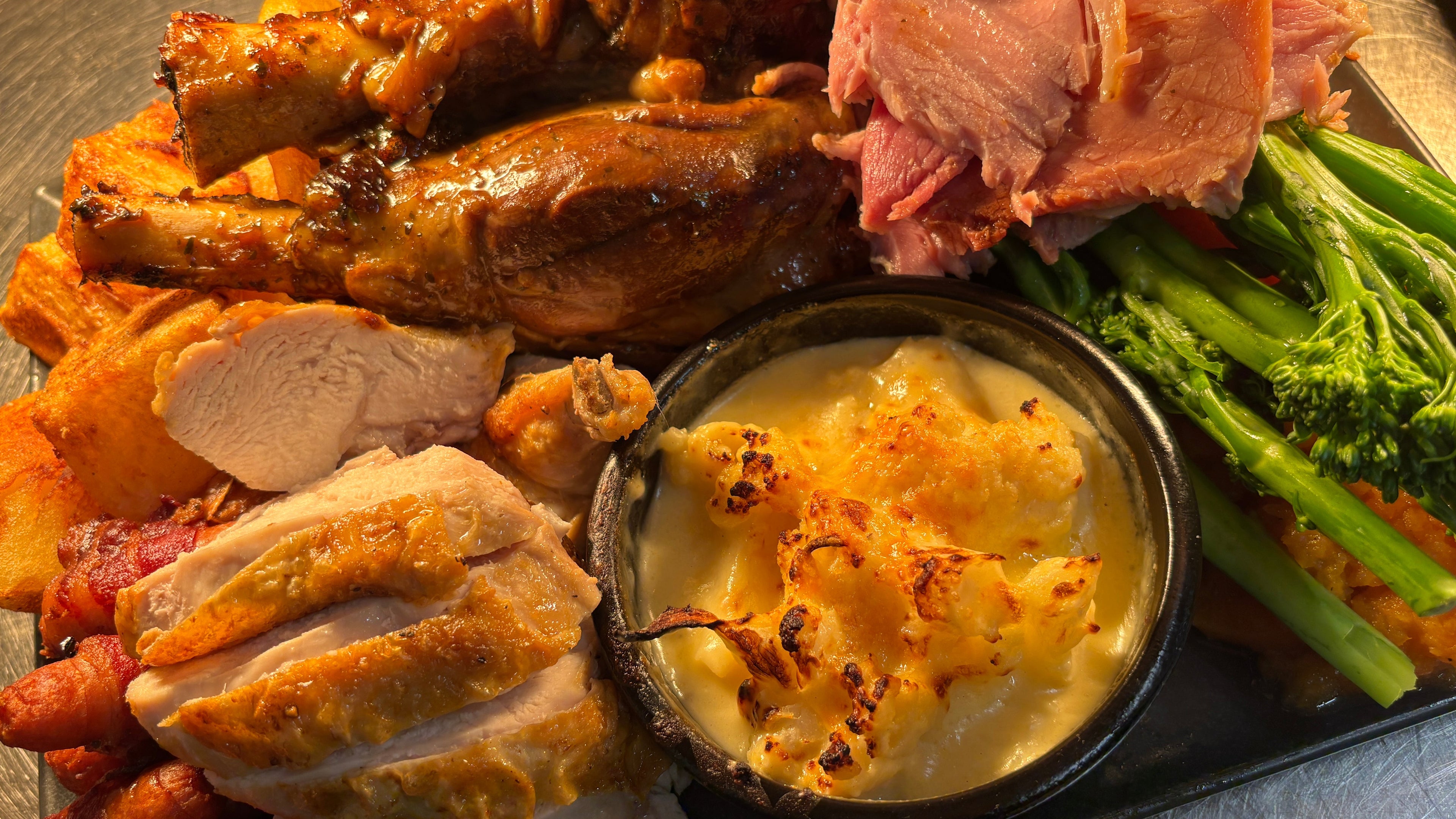 Plated dish with roasted chicken, vegetables, and a side of mashed potatoes.